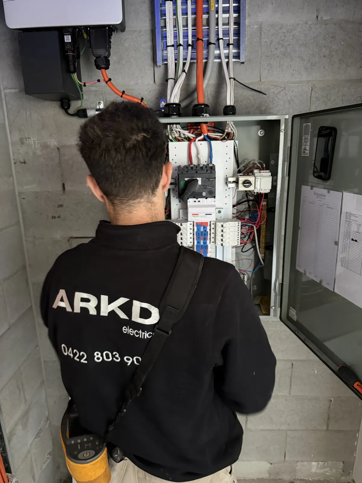 ARKD commercial electrician working on a high-rise switchboard in Brisbane