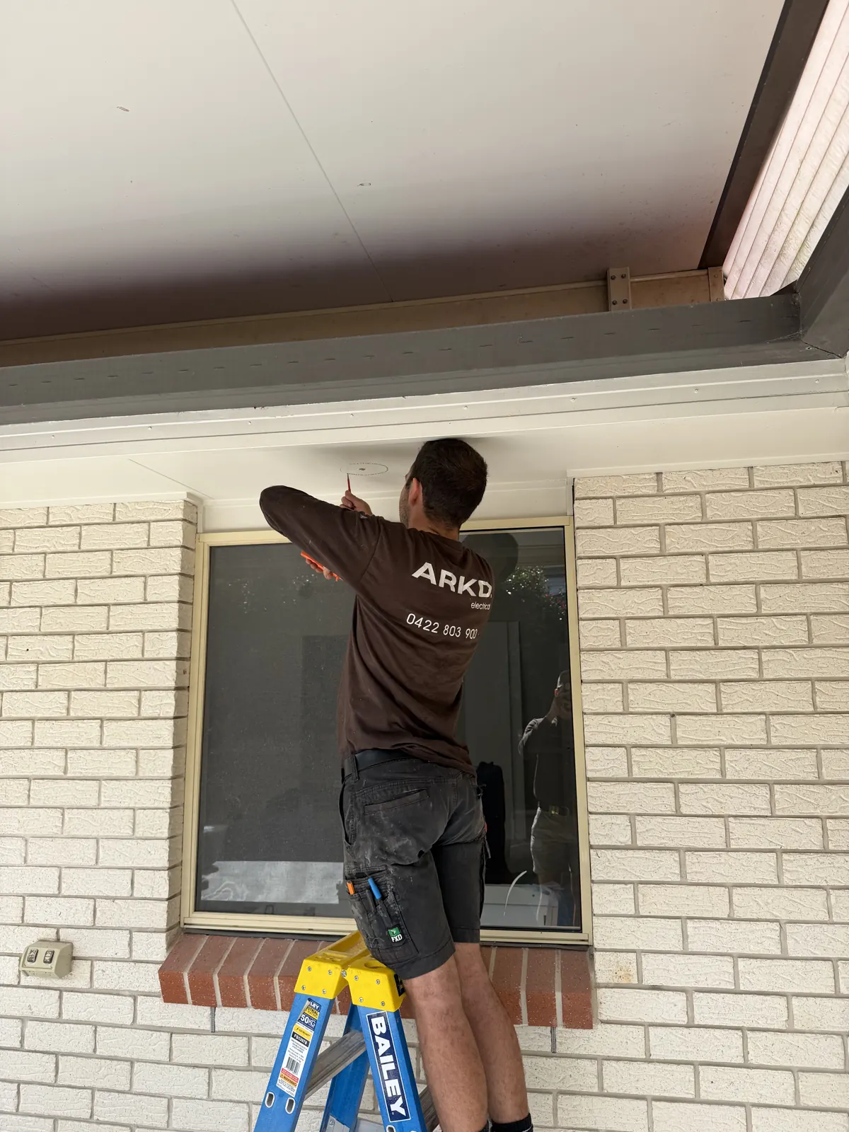 ARKD electrician installing LED eaves downlights at a Brisbane home